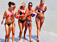 Not one or two but the whole company of sexy bikini hotties was noticed and recorded by the guy with camera on the beach
